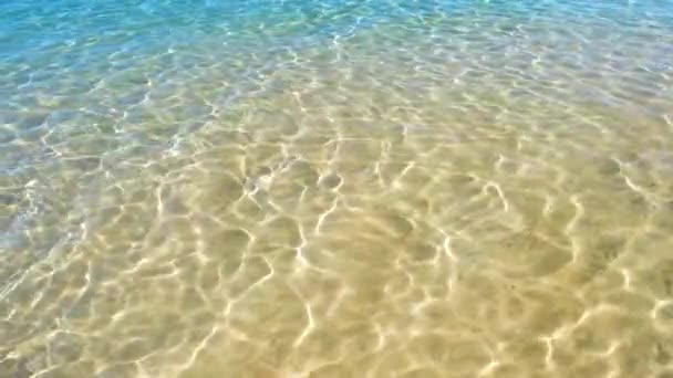 Морський пейзаж з поверхнею блакитної морської води з невеликими хвилями, що розбиваються на жовтому піщаному пляжі. Концепція подорожей та відпусток . — стокове відео