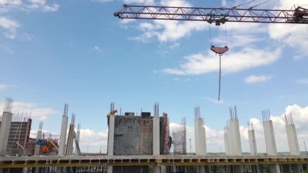 Turmdrehkräne und Arbeiter an einem hohen Betonwohnhaus im Bau. Immobilienentwicklungskonzept. — Stockvideo