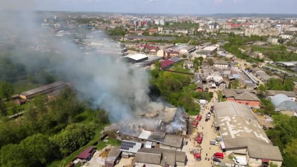 Vista aérea de bomberos extinguiendo edificio en ruinas en llamas con techo colapsado y humo oscuro ascendente — Vídeos de Stock