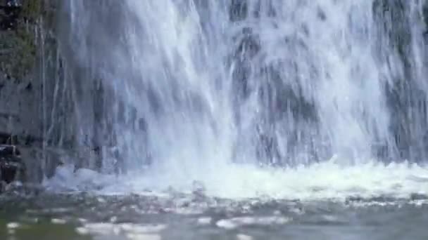 在夏天的热带雨林里，美丽的瀑布落在山河上，白色的泡沫般的水从岩石悬崖上滑落下来，风景迷人极了 — 图库视频影像