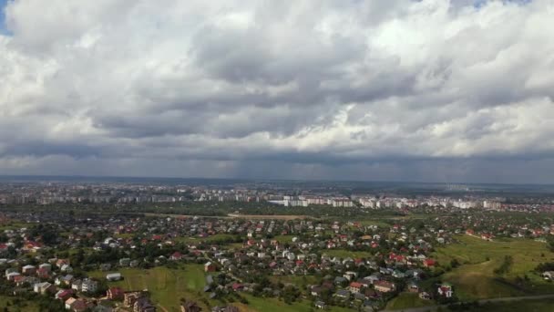 Vista aérea desde la gran altitud de la ciudad distante cubierta de nubes de cúmulos hinchados que se forman antes de la tormenta — Vídeos de Stock