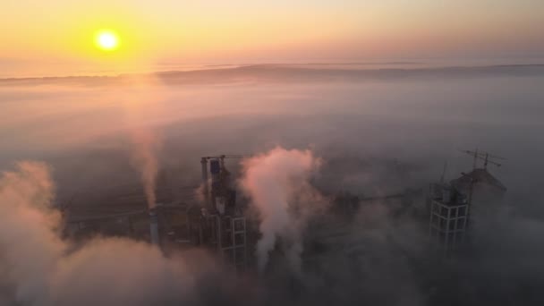 雾天早晨，工业园区内具有高混凝土厂房结构和塔式起重机的水泥厂的空中景观。制造业和全球工业概念 — 图库视频影像