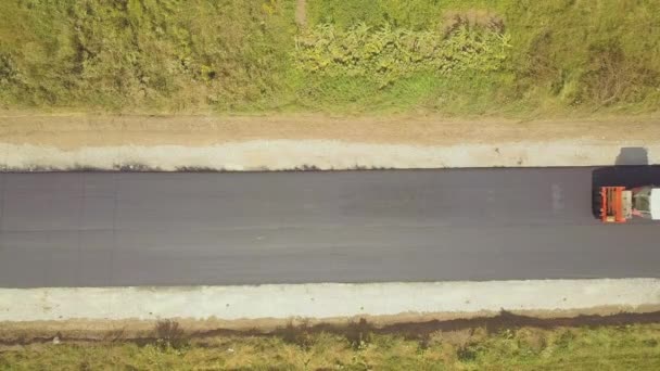 Вид с воздуха на новое дорожное строительство с паровым валиком за работой — стоковое видео