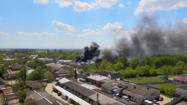 Letecký pohled na hasiče hasící zničenou budovu v plamenech se zhroucenou střechou a stoupajícím tmavým kouřem — Stock video