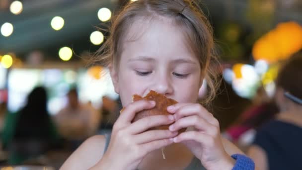 Kind isst leckeren Burger in Restaurant — Stockvideo