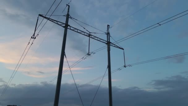 Dark silhouette of high voltage tower with electric power lines at sunset. Transfer of electricity concept — Stock Video