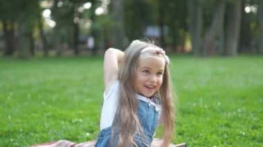 Mutlu çocuk oyuncak ayısıyla oynuyor yaz parkında yeşil çimlerde oturuyor