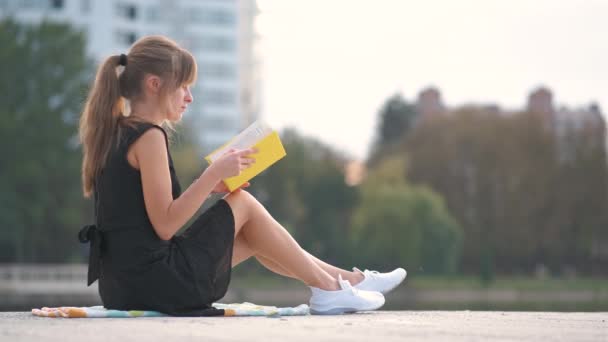Studentessa seduta nel parco estivo a leggere libri di testo all'aperto. Istruzione e sudy concept — Video Stock