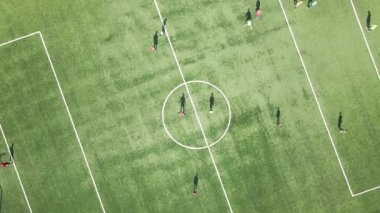 Yeşil spor stadyumunda futbol oynayan futbolcuların hava manzarası