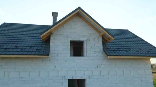 建筑中的有充气轻质混凝土墙和铺有金属砖的木制屋顶框架的未完工房屋的空中景观 — 图库视频影像