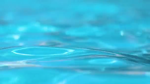 Nahaufnahme Oberfläche von blauem klarem Wasser mit kleinen Wellen im Schwimmbad — Stockvideo