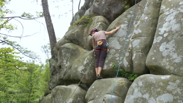 Starker männlicher Bergsteiger, der die steile Wand des felsigen Berges erklimmt. Sportler überwinden schwierige Strecke. Engagement im Extremsport Hobby-Konzept — Stockvideo