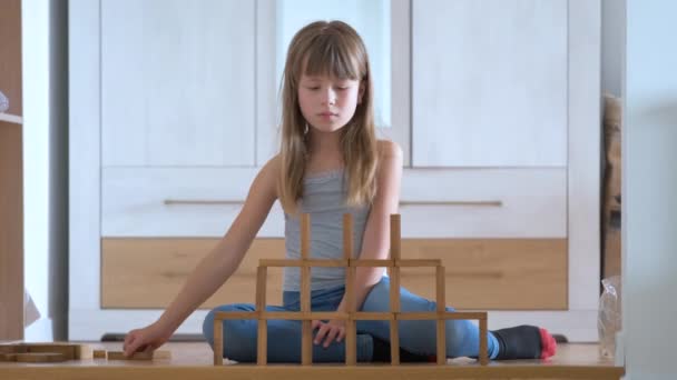 Glad barn flicka spelar jenga spel stapling trä leksaksblock i hög lugg struktur. Handrörelsekontroll och uppbyggnad av beräkningsfärdigheter — Stockvideo