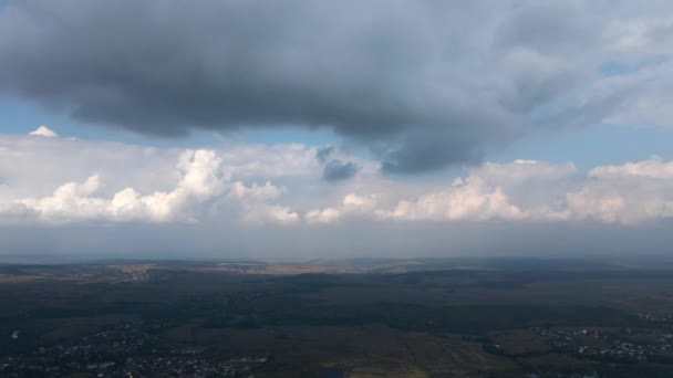 Αεροφωτογραφία από το παράθυρο του αεροπλάνου σε μεγάλο υψόμετρο της μακρινής πόλης που καλύπτεται με φουσκωτά σύννεφα που σχηματίζονται πριν από την καταιγίδα — Αρχείο Βίντεο