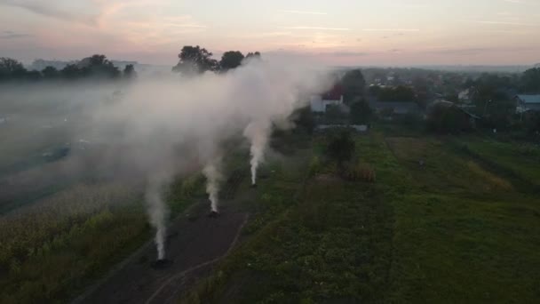 Αεροφωτογραφία των γεωργικών αποβλήτων από πυρκαγιές ξηράς χλόης και άχυρο που καίγονται με παχύ καπνό που ρυπαίνει τον αέρα κατά τη διάρκεια της ξηράς περιόδου σε γεωργικές εκτάσεις που προκαλούν υπερθέρμανση του πλανήτη και καρκινογόνους καπνούς. — Αρχείο Βίντεο
