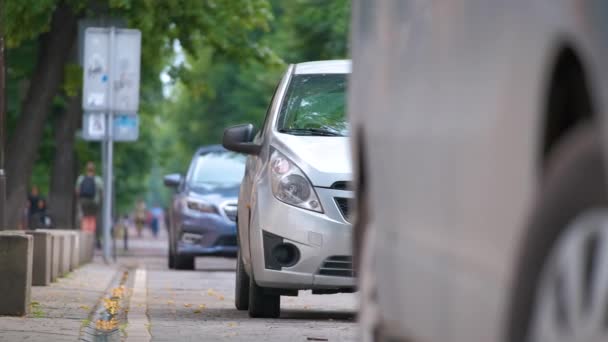 Tráfico urbano con coches estacionados en línea en el lado de la calle — Vídeo de stock