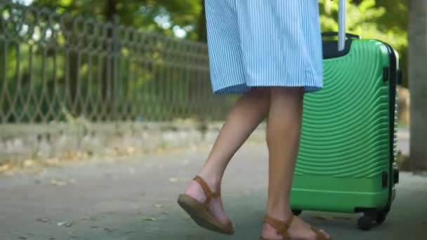 Mladá žena řidič uvedení zelený kufr uvnitř auta střešní nosič na City Street. Koncept cestování a dovolené — Stock video