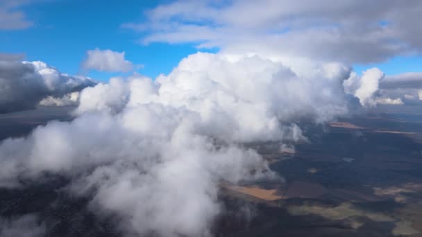 Luftaufnahme aus dem Flugzeugfenster in großer Höhe der Erde, bedeckt mit geschwollenen Kumuluswolken, die sich vor dem Regensturm bilden — Stockvideo