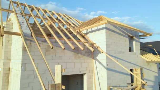 Widok z lotu ptaka niedokończonej ramy prywatnego domu z napowietrzonymi lekkimi betonowymi ścianami i drewnianą ramą dachową w budowie — Wideo stockowe