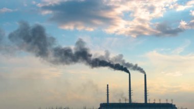 Termik santrale yakın siyah dumanlı yüksek borular atmosferi kirletiyor. Fosil yakıt kavramına sahip elektrik enerjisi üretimi