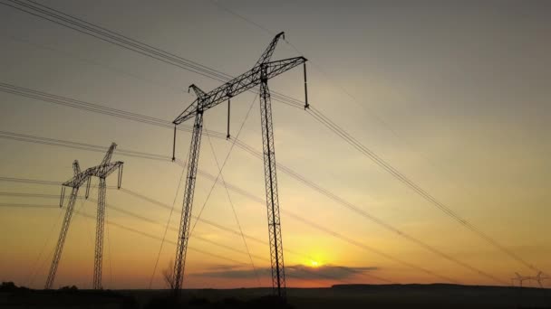 Hoogspanningstorens met elektrische leidingen bij zonsondergang — Stockvideo