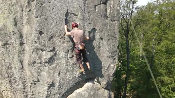 Escalador masculino fuerte escalando empinada pared de montaña rocosa. Deportista superando ruta difícil. Participar en el concepto de pasatiempo deportivo extremo — Vídeo de stock