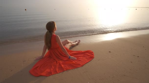 Jeune femme heureuse en robe rouge se détendre sur la plage de sable fin au bord de la mer profitant matin tropical chaud — Video