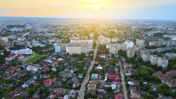 Uitzicht vanuit de lucht op hoogbouw appartementengebouwen, privéhuizen en straten in de woonwijk van de stad 's avonds — Stockvideo