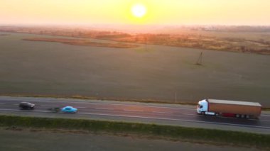 Akşamları kargo karavanıyla otobanda mal taşıyan yarı kamyonun hava görüntüsü. Teslimat ulaşım ve lojistik kavramı