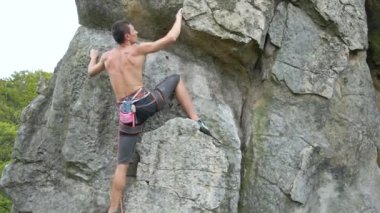 Kararlı dağcı kayalık dağın dik duvarına tırmanıyor. Sporcu zor yolu aştı. Ekstrem sporlar ve kaya tırmanışı hobileri.