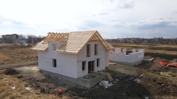 Vista aérea de quadro inacabado de casa particular com paredes de concreto leve aerado e estrutura de telhado de madeira em construção — Vídeo de Stock