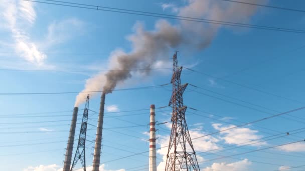 Pylons elétricos de alta tensão contra tubos altos de usina de carvão com fumaça preta movendo-se para cima atmosfera poluente. Produção de energia elétrica com conceito de combustível fóssil — Vídeo de Stock
