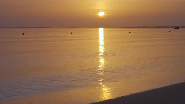Spokojny brzeg morza z falami kruszenia na piaszczystej plaży o wschodzie słońca — Wideo stockowe
