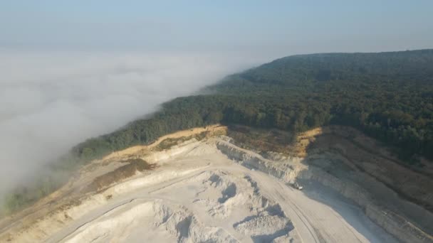 Aerial view of open pit mining of limestone materials for construction industry with excavators and dump trucks — Stock Video