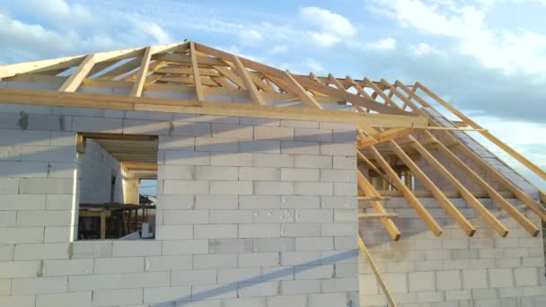 Vista aérea del marco inacabado de la casa privada con paredes de hormigón ligero aireado y marco de techo de madera en construcción — Vídeos de Stock