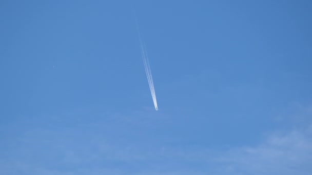Mesafeli yolcu jet uçağı açık mavi gökyüzünde yüksek irtifada uçarken ardında beyaz duman izi bırakıyor. Hava taşımacılığı kavramı — Stok video