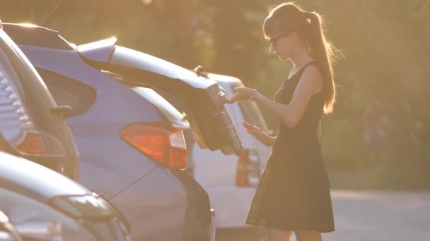 Junge Autofahrerin holt Gepäcktasche aus ihrem Auto Reise- und Urlaubskonzept — Stockvideo