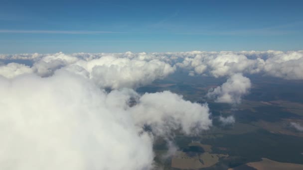 Vista aérea da janela do avião em alta altitude da terra coberta com nuvens de cúmulo inchadas brancas — Vídeo de Stock