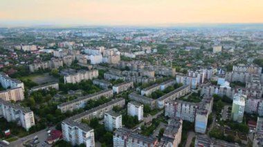 Gökyüzü manzaralı apartman binaları, özel evler ve sokaklar akşamları şehir yerleşim bölgesinde.
