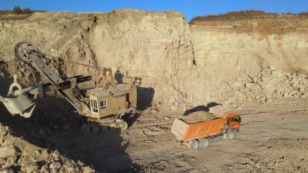Vista aérea de mina a cielo abierto de materiales de arenisca para la industria de la construcción con camión volquete de carga de excavadoras con piedras. Equipo pesado en minería y producción de minerales útiles concepto — Vídeos de Stock