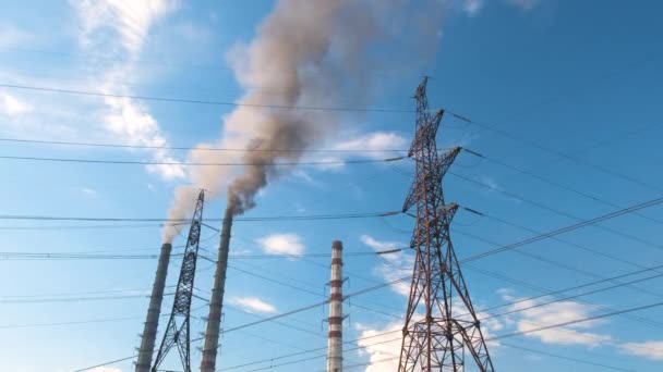 Hoge spanning elektrische pylonen tegen kolencentrale hoge buizen met zwarte rook verplaatsen naar boven vervuilende atmosfeer. Productie van elektrische energie met fossiele brandstoffen — Stockvideo