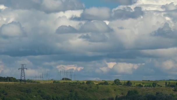 Zeitraffer-Aufnahmen von sich schnell bewegenden weißen, geschwollenen Kumuluswolken am blauklaren Himmel über Hochspannungsleitungen — Stockvideo