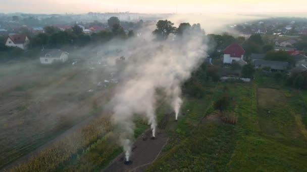 Αεροφωτογραφία των γεωργικών αποβλήτων από πυρκαγιές ξηράς χλόης και άχυρο που καίγονται με παχύ καπνό που ρυπαίνει τον αέρα κατά τη διάρκεια της ξηράς περιόδου σε γεωργικές εκτάσεις που προκαλούν υπερθέρμανση του πλανήτη και καρκινογόνους καπνούς. — Αρχείο Βίντεο