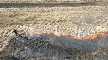 İtfaiyecilerin kurak mevsimde yanan çayır tarlasını havadan görünüşü. Doğal afet ve iklim değişikliği kavramı
