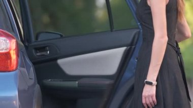 Genç bir kadın sürücü, arabasından bavul çantası çıkarıyor. Seyahat ve tatil kavramı