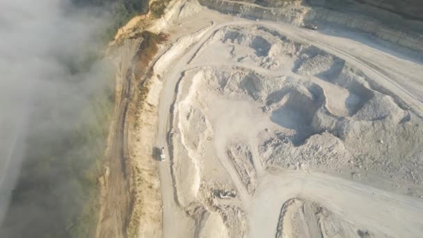 Vista aérea da mineração a céu aberto de materiais de pedra calcária para a indústria da construção com escavadoras e caminhões basculantes — Vídeo de Stock