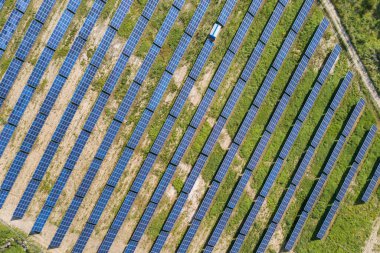 Yeşil alandaki güneş enerjisi santralinin havadan görüntüsü. Temiz ekolojik enerji üretmek için panelleri olan elektrik çiftliği.