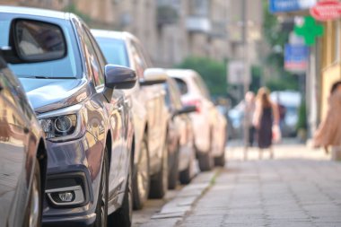 Sokak kenarında park halindeki arabalarla şehir trafiği.