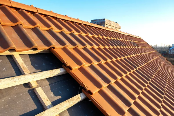 建築中の住宅用屋根を覆う板に取り付けられた黄色のセラミック屋根瓦の重なり合う列 — ストック写真