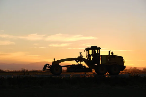 Силуэт Тяжелого Трактора Движущегося Дороге Закате — стоковое фото